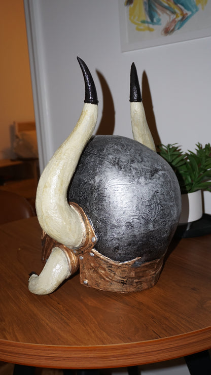 a black and white horned sculpture on a wooden table.